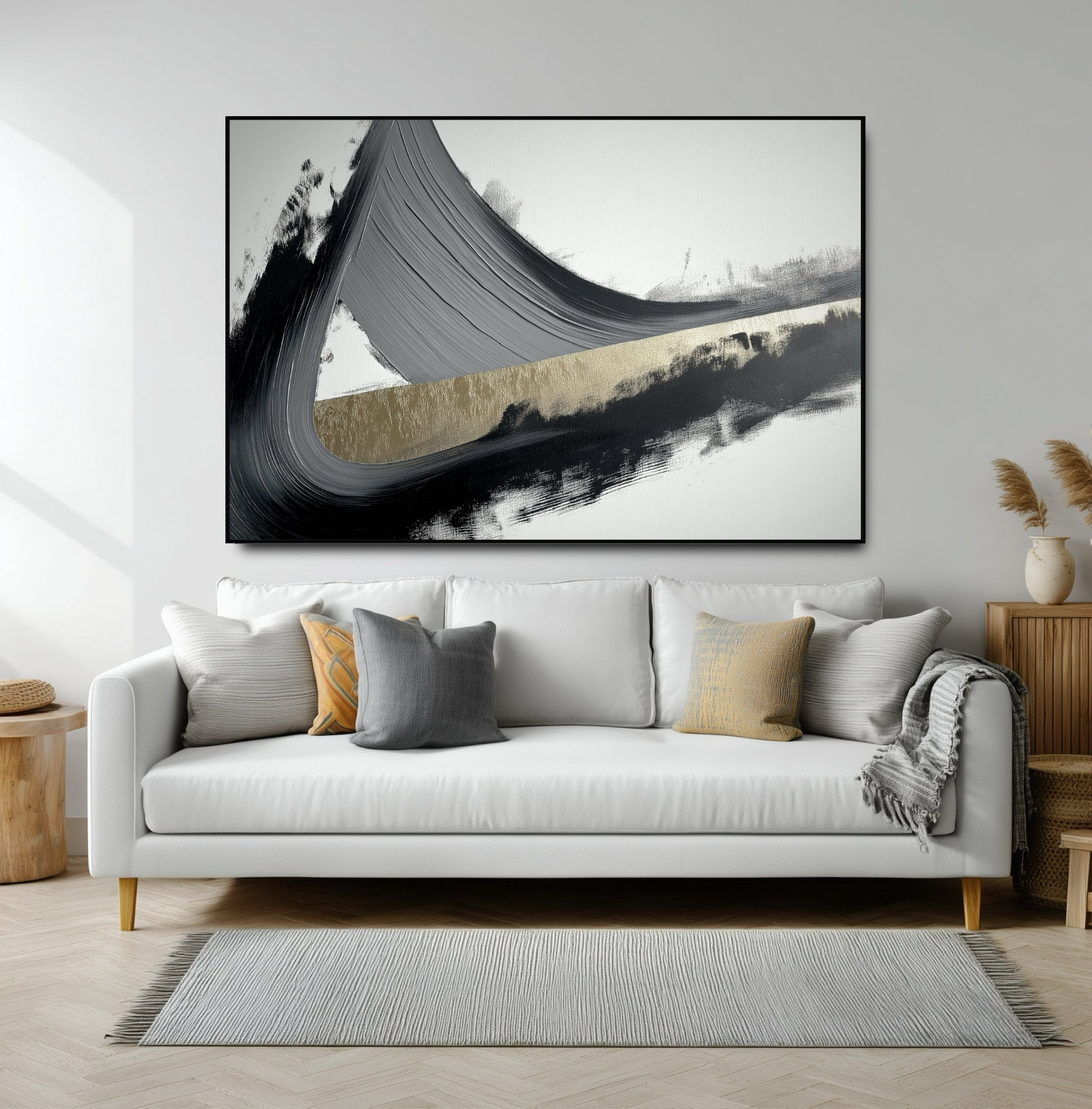 Large horizontal abstract with a powerful black and gold brushstroke over a modern white sofa in a bright living room.