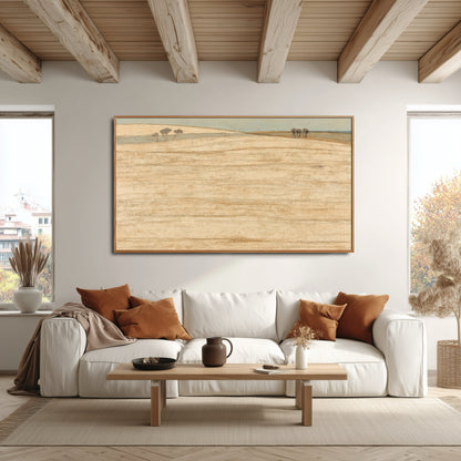 Expansive original landscape art complements the rustic wood ceiling beams and modern sofa with accent pillows in an airy space.