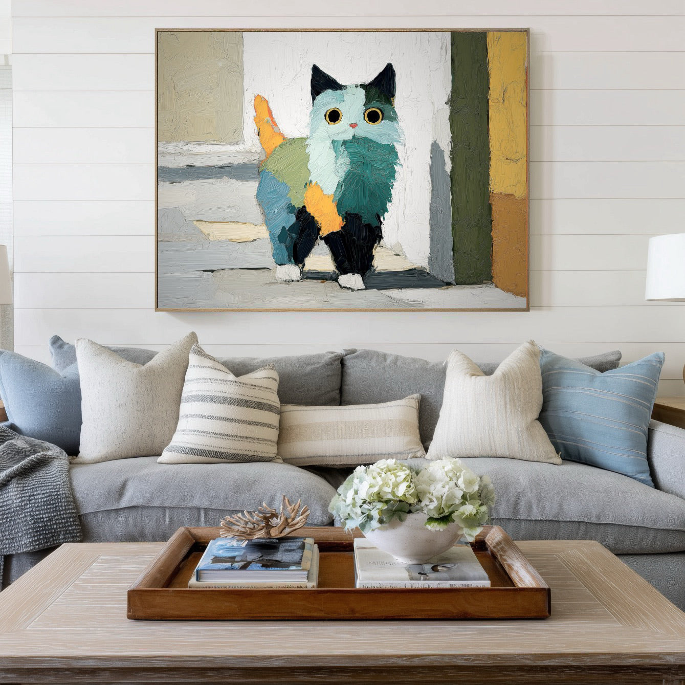 Abstract cat fine art adds color contrast over a gray sofa in a light, comfortable coastal-style living room.