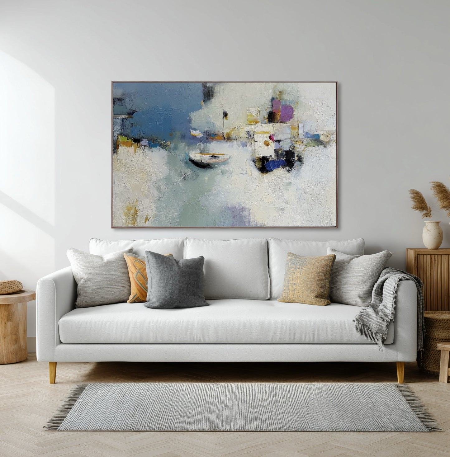 Abstract harbor art over a white sofa, seamlessly integrating the gold and grey pillow accents into the modern, soft-lined decor.