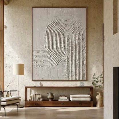 Textured neutral art central to an earthy room, complementing the dark wood console and rough plaster wall finish.