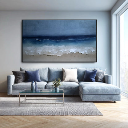 The large seascape painting's blue tones create a cohesive, monochromatic look with the light blue sectional in this modern, bright room.