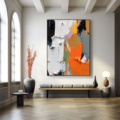 Textured abstract art providing a bold focal point over a low bench in a minimalist hall with elegant arched windows.