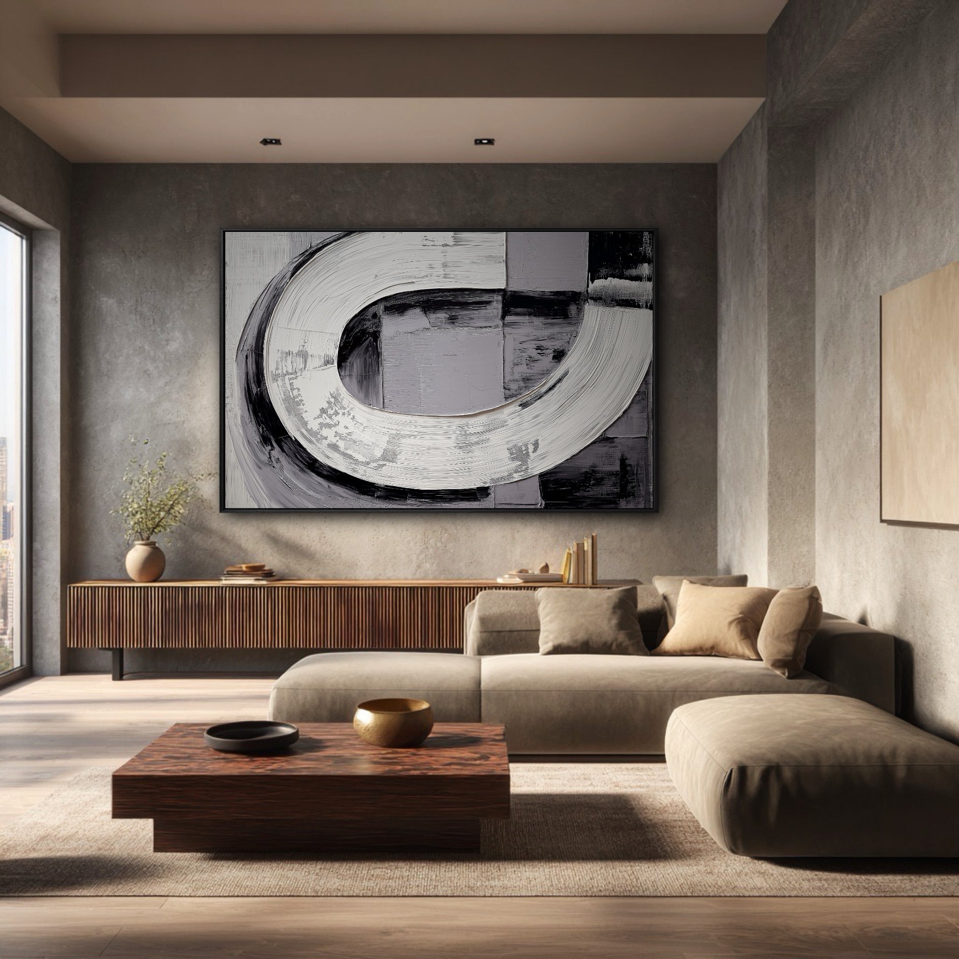 Horizontal black and white textured art on a concrete wall in a moody, industrial-style living room with a low sofa.