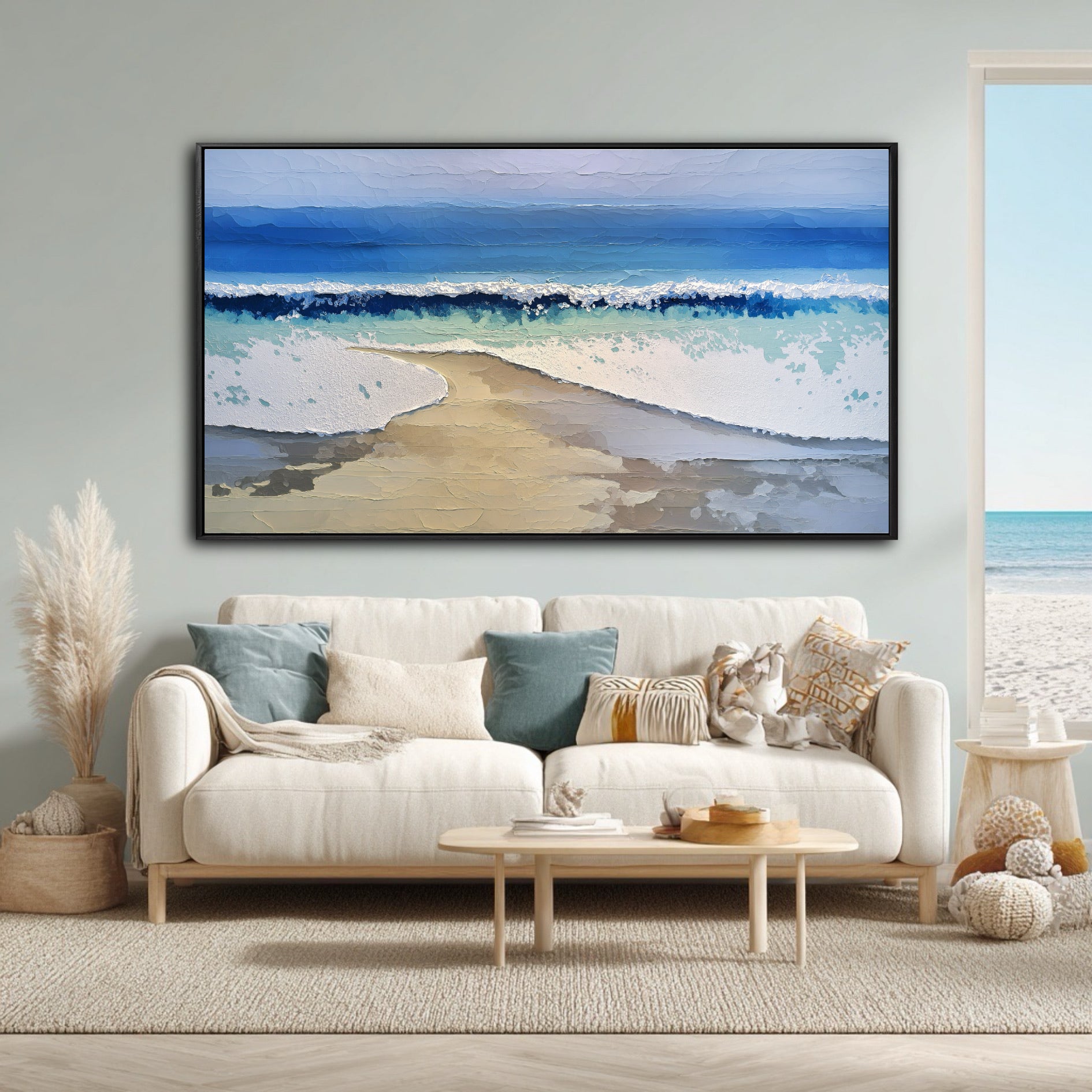 The abstract beach painting enhances the room's airy, coastal boho theme, complementing the pampas grass and the window's ocean view.