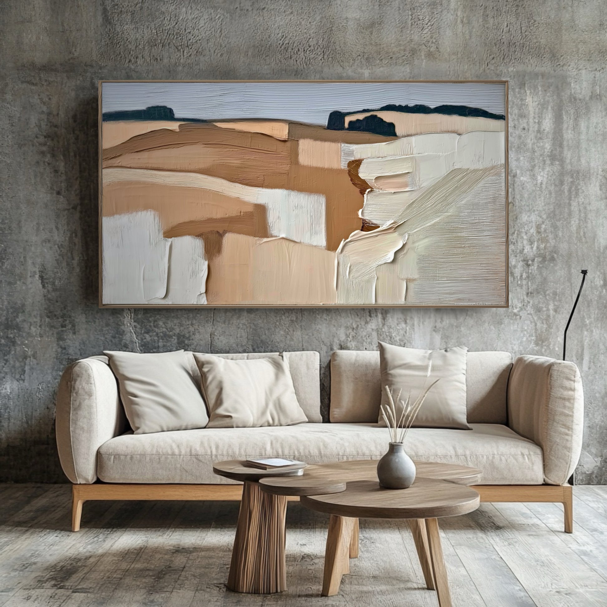 Warm abstract art softens the raw, industrial concrete wall, providing organic texture and color contrast to the sleek, minimalist sofa.
