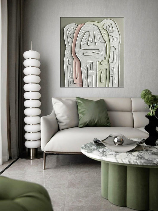 Muted abstract canvas over a streamlined white modern sofa next to a sculptural lamp in a mid-century influenced room. 