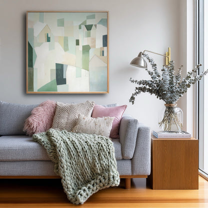 Living room with a gray sofa, an abstract painting, and decorative items.