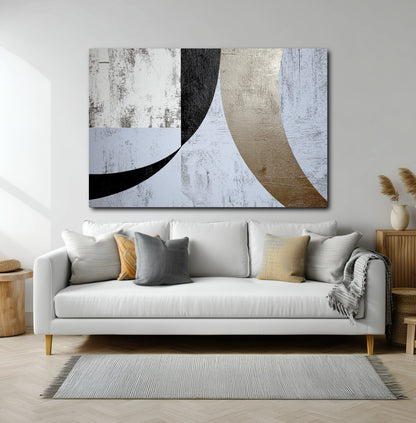 Large horizontal abstract with black and gold curves over a modern white sofa in a bright, contemporary living room.