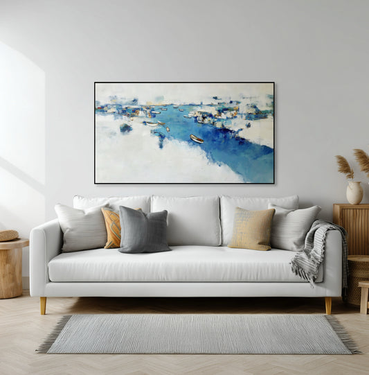 Large abstract blue harbor art above a white sofa, providing serene color depth and harmonizing with the neutral, clean, modern room.