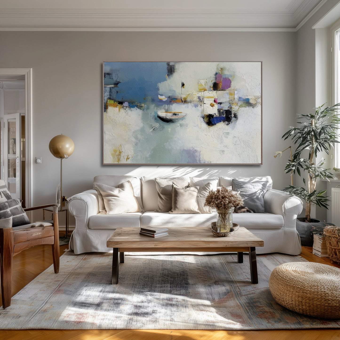 Abstract harbor reflection art adding ethereal lightness above a linen sofa, elevating the transitional room's warm wood and patterned rug.
