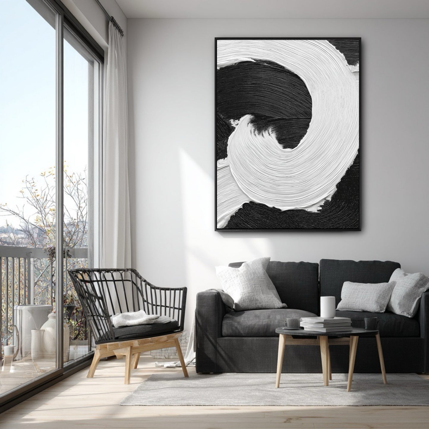 Vertical black and white abstract art on a white wall in a modern apartment with a grey sofa and a balcony.