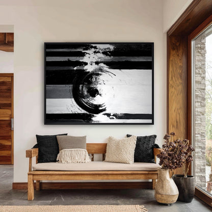 Large horizontal black and white painting above a natural wood bench with textured pillows in a rustic modern entryway.