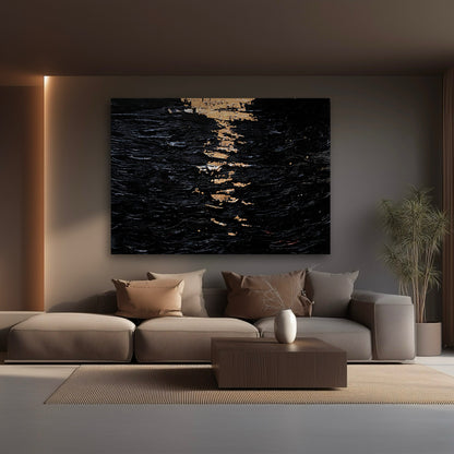 A black and gold abstract canvas hangs on a brown, softly lit wall in a modern living room, centered above a large beige sectional sofa.