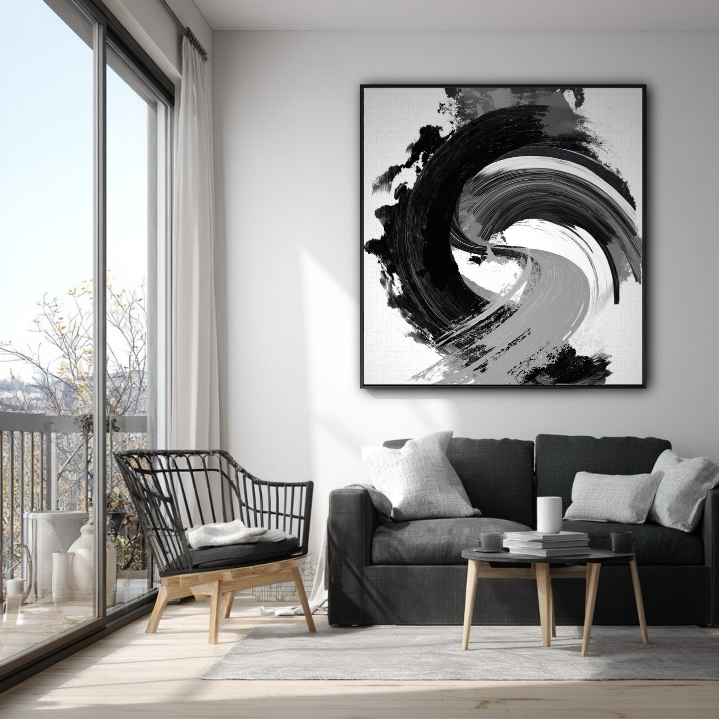 Vertical black and white gestural art on a white wall in a modern apartment with a grey sofa and a balcony.