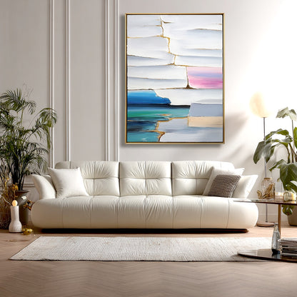 Modern living room with a white sofa, abstract painting, and decorative items.