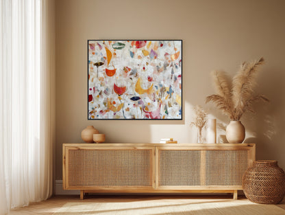 Vibrant original abstract floral art displayed over a rattan console, complementing the warm beige walls and pampas grass decor.