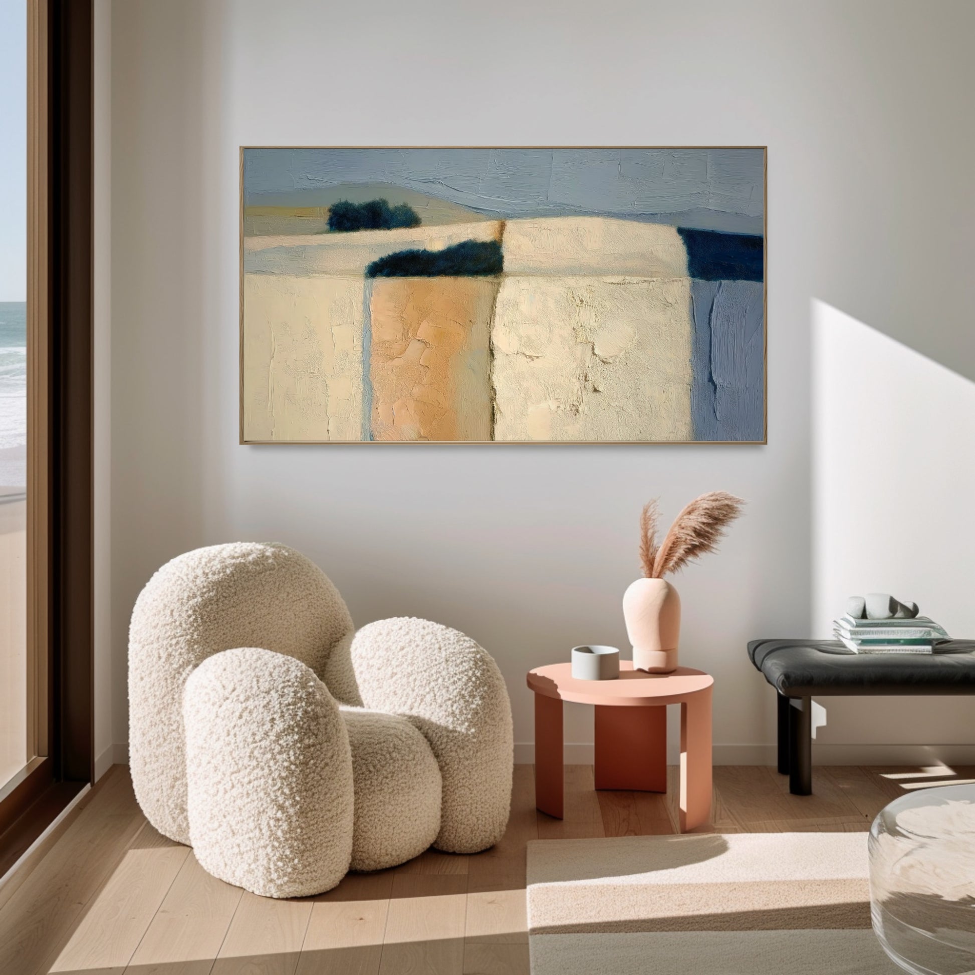 Original abstract landscape brightens a cozy corner with a cream boucle chair. Natural light and peach accents create a soft, inviting retreat.
