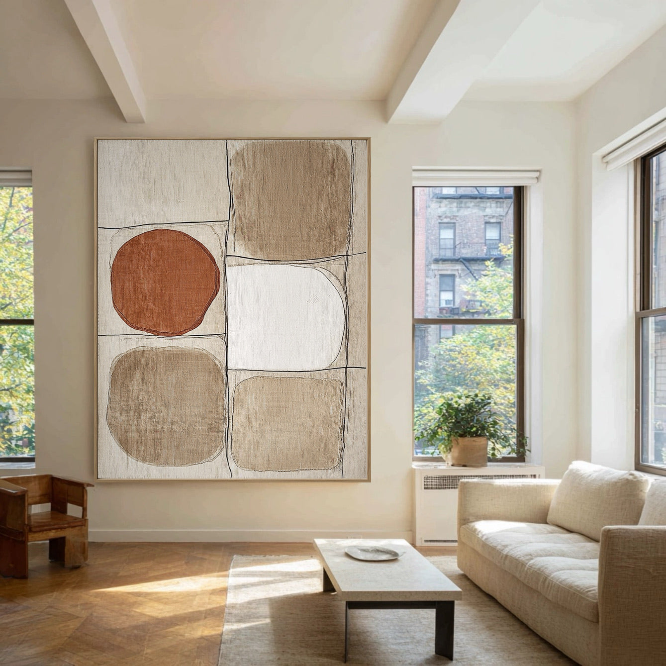 Neutral geometric art dominating a sunny loft living room with high ceilings, large windows, and a comfortable white sofa.