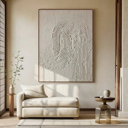 Original art over a light, zen-style chaise, integrating with sunlit walls and natural wood accents for calm.