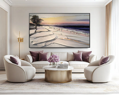 Original textured sunset beach painting centered above a luxurious cream sofa with plush velvet purple pillows, adding a serene and elegant focus.