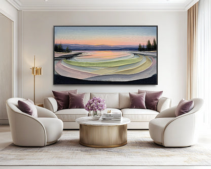 Original abstract landscape artwork provides a calm, colorful focus above a cream sofa, complemented by elegant velvet chairs and purple pillows.