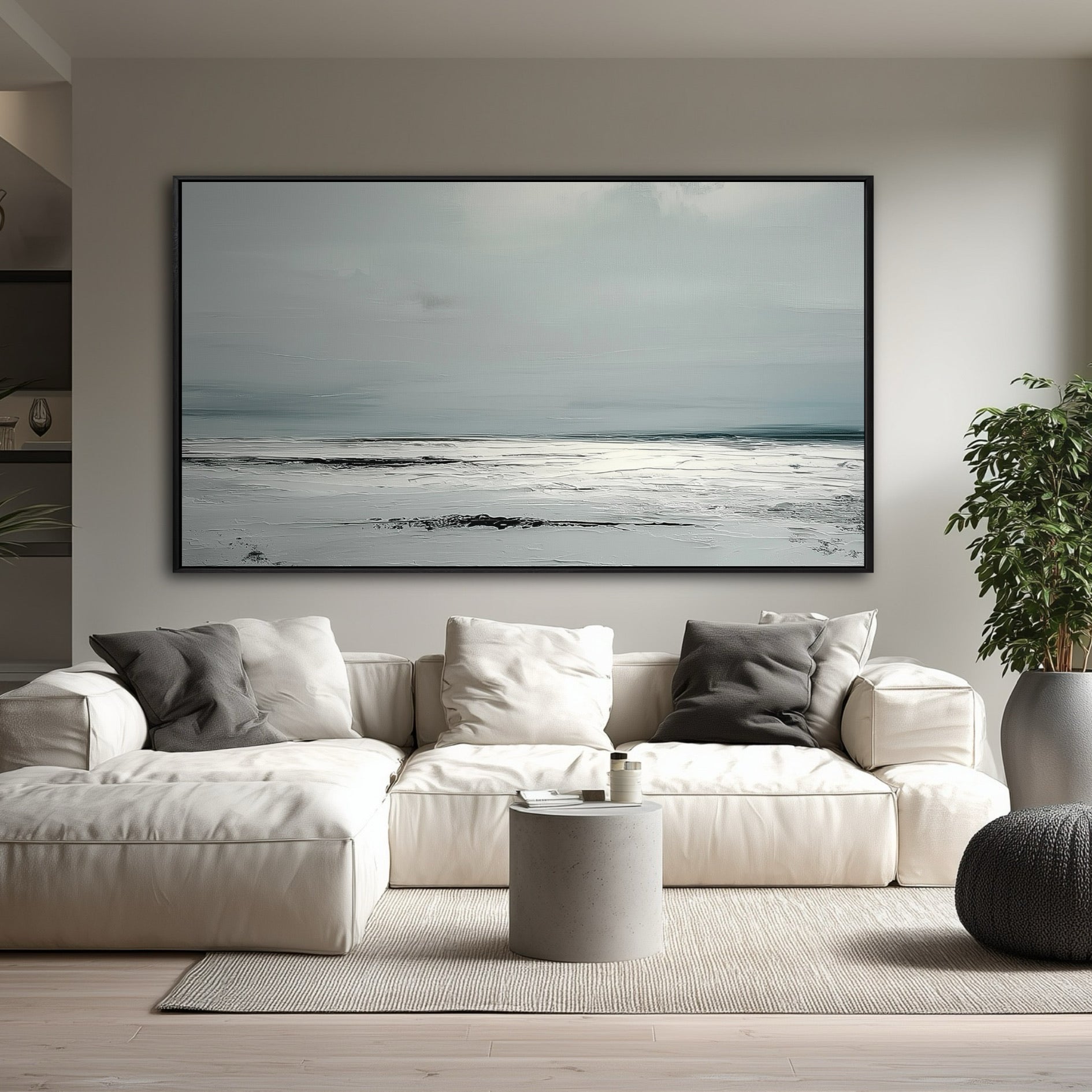 A large, minimalist gray and white abstract painting hangs in a modern living room above a large white sectional sofa.