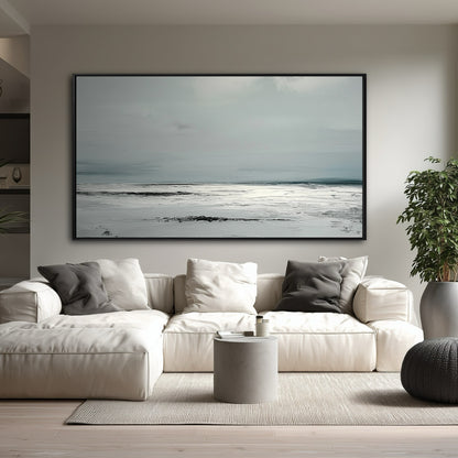 A large, minimalist gray and white abstract painting hangs in a modern living room above a large white sectional sofa.