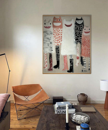 Whimsical abstract painting hangs over a vintage leather chair and dark wood table, adding modern character to a cozy, eclectic space.