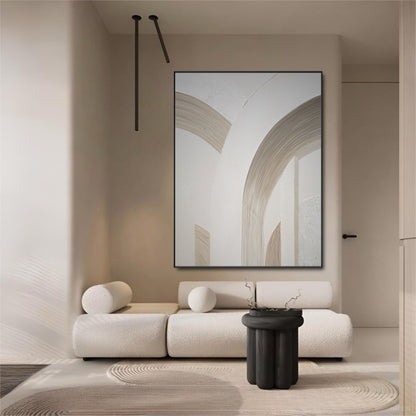 Large abstract arch art in an ultra-minimalist room with a white bouclé sofa and a stark black side table.