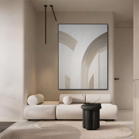 Large abstract arch art in an ultra-minimalist room with a white bouclé sofa and a stark black side table.